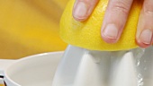 Squeezing a lemon with an electric citrus squeezer (close-up)