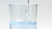 Mineralwasser in ein Glas gießen