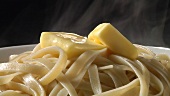 Cooked ribbon pasta with knobs of butter