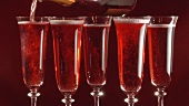 Pouring sparkling rosé wine into glasses