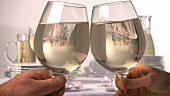 Clinking glasses of white wine
