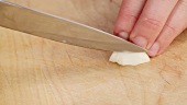 Halving a garlic clove and chopping roughly