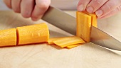 Chopping lengths of carrot into julienne strips