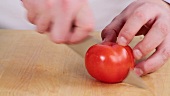 Tomate in Stücke schneiden