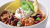 Chilli con carne served with sour cream and tortilla chips