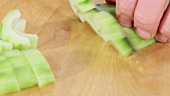 Chopping a peeled and deseeded cucumber into small pieces