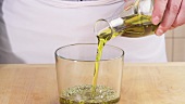 Olivenöl zu der Kräutermarinade geben