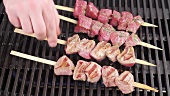 Marinated lamb kebabs being turned on a barbecue