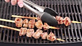 Grilled lamb kebabs being removed from the barbecue