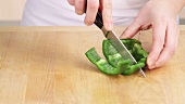 A green pepper being sliced