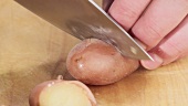 A potato cooked in its skin being chopped