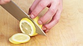 Eine Zitrone in Scheiben schneiden