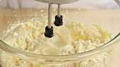 Biscuit dough being stirred with a hand mixer