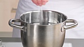 Salt being added to a saucepan of water