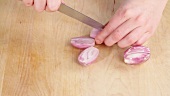 Peeled shallots being halved