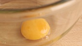 An egg being beaten in a bowl
