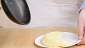 An omelette being transferred to a plate