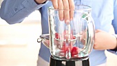 Strawberries being added to a blender