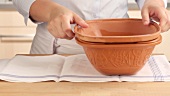 A watered clay pot being drained