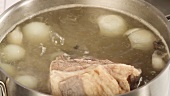 Cooked beef being removed from soup