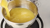 Orange juice and softened gelatine being placed in a pot