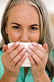 Mature woman drinking tea, portrait, close-up