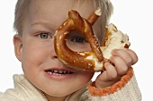 Little boy holding partly-eaten pretzel