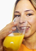 Young woman drinking orange juice, close-up