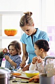 Mother and two children preparing meal in kitchen