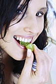 Young woman eating grape
