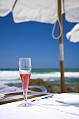 Sangria in sparkling wine glass on table on beach