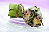 Banana leaves with rice and banana stuffing, cut in two