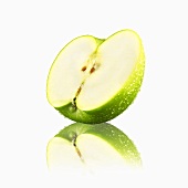 Halber grüner Apfel mit Wassertropfen und Reflexion