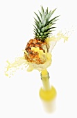 Pineapple juice splashing out of bottle