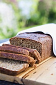 Wholemeal bread, partly sliced, on wooden table