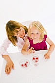 Mother and daughter, daughter holding a raspberry ice cube