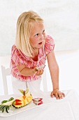 Girl eating pitahaya from plate of fruit