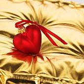 Rotes Herz (Baumanhänger) auf goldenem Kissen