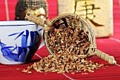 Millettia stem in tea strainer with bowl of tea