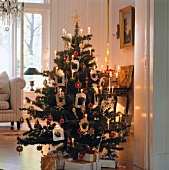 Christmas tree decorated with photo frames and lit candles