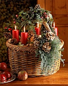 Adventsgesteck im Korb, vier rote Kerzen mit Tannenzapfen, Brombeeren