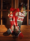 Bedruckte Nikolausstiefel aus Stoff hängen an einer Schranktür