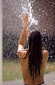 Laanghaarige Frau wird von Wasserstrahl naßgemacht