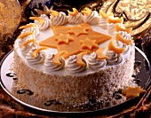 Sahnetorte mit orangefarbenen Marzipansternen und Mondsicheln