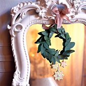 Close-up of small wreath with stars hanging on the frame of mirror