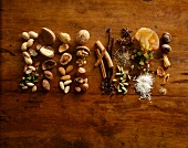 Various spices and nuts arrange in rows on wooden surface, overhead view