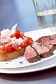 Close-up of lamb fillet with tomato on toast