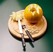 Carved honeydew melon cut in zig zag patter on chopping board