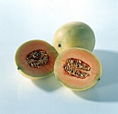 Eine ganze und eine halbierte Orange-Flesh-Melone