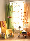 Room with floral curtains and yellow armchair cover with pockets
